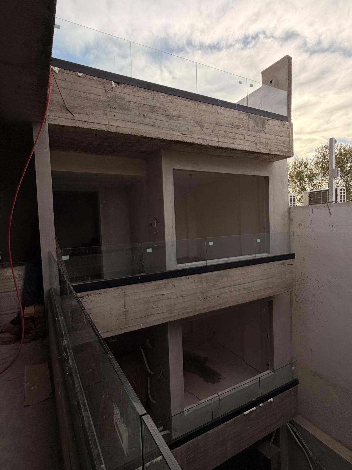 Balcones del edificio de J. V. González 4562 con barandas de vidrio